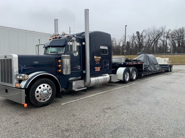 A black semi-truck in a remote parking lot.